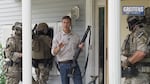 In a new campaign ad, Eric Greitens carries a shotgun and stands alongside men in military gear as they break into a home.