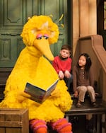 In this 2008 file photo, Big Bird reads to Connor Scott and Tiffany Jiao during a taping of Sesame Street in New York.