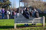 Students from Hudson's Bay High School sit on a Vancouver Public Schools administration sign during a protest on Jan. 6, 2025.