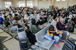 People sit in the waiting area at the Rafah border crossing in the southern Gaza Strip before crossing into Egypt on Wednesday.