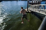 A man jumps into the Willamette River in Portland. City officials expect more people to take to the water this summer.