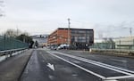 highway overpass in foreground, multi-story brick building in background