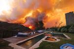 A brush fire burns near homes