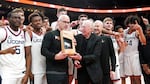 The Connecticut basketball team poses with Nike founder Phil Knight, center left, after winning the championship against Iowa State in the Phil Knight invitational Sunday, Nov. 27, 2022, in Portland, Ore.