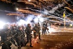 FILE - Police use chemical irritants and crowd control munitions to disperse protesters during a demonstration in Portland in 2020, on the 100th consecutive day of protests.