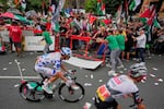People hold Palestinian flags as they try to disrupt the eleventh stage of the Spanish Vuelta cycling race, from Bilbao to Bilbao, Spain, Wednesday, Sept. 3, 2025.