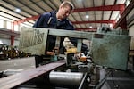 Thomas Van Hoose operates a band saw to cut a piece of steel for an order while working at Swift Steel in Redmond, Ore. Van Hoose obtained his commercial driver’s license through WorkSource Oregon, a program he learned about while incarcerated. Van Hoose said the CDL has helped with employment opportunities.