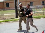 Police walk near Robb Elementary School following a shooting, Tuesday, May 24, 2022, in Uvalde, Texas.
