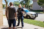 Officer Nicole Schmitgen speaks with a man about a reported disturbance in his home during her patrol on July 18, 2022.