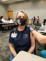 Michelle Wilson receives a coronavirus vaccine at Barnes-Jewish Hospital in St. Louis, Mo. Wilson had gotten COVID earlier in the pandemic, before vaccines were available.