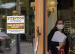 FILE - In this May 21, 2021 file photo, a sign reminds customers to wear their masks at a bakery in Lake Oswego, Ore. Oregon Gov. Kate Brown on Tuesday, Aug. 10, 2021 announced a statewide indoor mask requirement due to the spike in COVID-19 hospitalizations and cases, warning that the state's health care system could be overwhelmed.