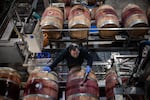 An employee fills oak barrels with cabernet sauvignon wine, made from the 2023 harvest, in a cellar at the Golan Heights Winery in Katzrin, the Golan Heights, on Jan. 8.