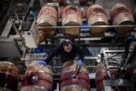 An employee fills oak barrels with cabernet sauvignon wine, made from the 2023 harvest, in a cellar at the Golan Heights Winery in Katzrin, the Golan Heights, on Jan. 8.