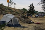 A tent pitched near U.S. Hwy. 97 in Bend in 2021. Cheyenne Purrington, director of the Coordinance Houseless Response Office, resigned from her position Tuesday. She cited a lack of vision among area elected officials as part of the reason.