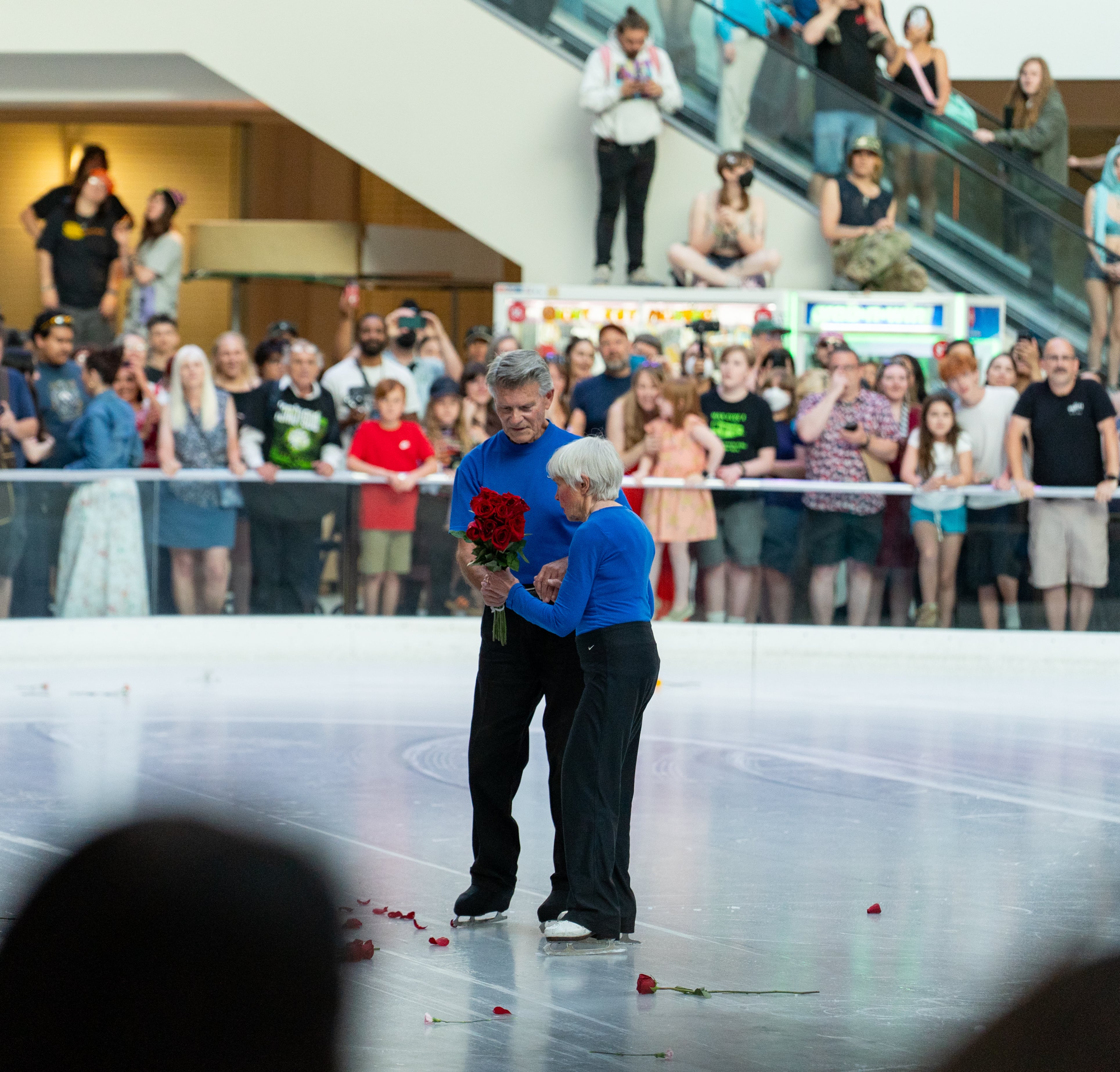 Jerry Leonard, left, gives Tally Leonard, right, a bouquet of roses tossed to the ice following their final skate.