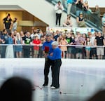 Jerry Leonard, left, gives Tally Leonard, right, a bouquet of roses tossed to the ice following their final skate.