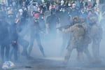 U.S. Customs and Border Protection agents standoff against demonstrators as tear gas fills the air outside the federal ICE building during a protest in Portland, Ore., on June 14, 2025.