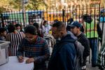 Jay Alfaro (center) helps migrants at the Church of the Holy Apostles in Manhattan earlier this month.