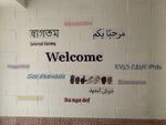 A wall in an exterior corridor of the Muslim Community Center on the Highway to Heaven in Silver Spring, Maryland has the word "welcome" written in many languages.