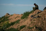 An Israeli soldier sits on a hill on Israel's southern border with the Gaza Strip on Thursday, March 7.