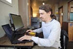 FILE: Ryne Smith works at the CyberMill internet café in Seneca, Ore., in 2022. Grant County’s economic development office helped CyberMill open so that people could get free, reliable, fast internet access. Oregon will receive $688 million from the Bipartisan Infrastructure Law to improve broadband internet access in undercovered areas like Grant County.