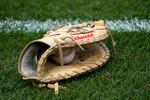 FILE: The Rawlings baseball glove of Chicago Cubs' Frank Schwindel lays next to the third base foul line before a baseball game against the San Diego Padres Wednesday, June 15, 2022, in Chicago.