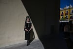 A woman wearing a traditional shawl known as a "mantilla" stands outside the Basilica de la Macarena church during Holy Week in Seville on April 2, 2026.