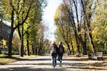 Hanna Korchevska and her son Ulysses walk through a park in Lviv. Sharing the single room between the four family members means they spend a lot of time out walking to avoid the cramped space.
