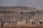 Palestinians carry humanitarian aid packages near a Gaza Humanitarian Foundation distribution center operated by the U.S.-backed organization, in Netzarim, central Gaza Strip