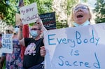 Chloe Latuvnik, 13, of Kenosha, Wisc., right, chants with her mothers Joy and Marianne Latuvnik-Morin, left and center, as they attend a rally in downtown Portland, Ore. where thousands of people gathered on Friday, June 24, 2022, to protest the U.S. Supreme Court's decision to overturn Roe v. Wade.