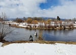 Lottie Riddle and Carlie Sharpes, Hydrologic Technician and Aquaculturist with the Klamath Tribes, release young Chinook salmon into the Wood River above Upper Klamath Lake.