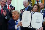 President Trump holds up a bill funding immigration enforcement after signing it in the Oval Office of the White House, Wednesday, June 10, 2026, in Washington.