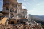 Rescue workers use excavators to remove the rubble of a destroyed building that was hit Tuesday night in an Israeli airstrike, as they search for victims in Barja, Lebanon, Wednesday, Nov. 6, 2024.