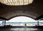 Port of Portland spokesperson Kama Simonds stands beneath a skylight of the airport's new wooden roof, July 5, 2022. Its construction is meant to evoke dappled forest light.
