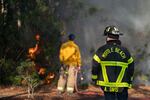 Firefighters attend to a flare-up in the Carolina Forest neighborhood on Sunday in Myrtle Beach, S.C. 