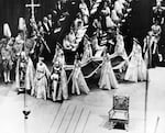 June 2, 1953: Queen Elizabeth II, surrounded by the bishop of Durham Lord Michael Ramsay (left) and the bishop of Bath and Wells Lord Harold Bradfield, walks to the altar during her coronation ceremony in Westminster Abbey, London, as her maids of honor carry her train.