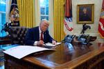 President Trump signs executive orders in the Oval Office at the White House, Jan. 30.