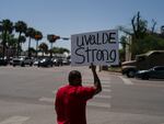 Alex Covarrubias, 32, holds up a sign at a street corner for the victims of Tuesday's shooting Robb Elementary School in Uvalde, Texas, Thursday, May 26, 2022.