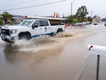 A truck is driven through a flooded intersection of Salinas, Calif., on Tuesday. The first in a week of storms brought gusty winds, rain and snow to California on Tuesday, starting in the north and spreading southward.