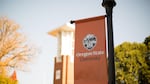An orange banner affixed to a light pole reads "Oregon State University," while a campus building is visible in the background.