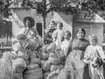 A photo of Martha Jane Sands, second from right, with her family a pile of baskets she made.