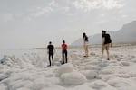 Visitors, including Dead Sea researcher Yael Kiro from Israel's Weizmann Institute of Science (second from left), examine salt formations on the shore of the Dead Sea in Israel on Nov. 5.