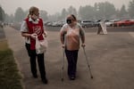 Mary Thomson, left, from Phoenix gets assistance from Salvation Army officer Tawnya Stumpf at the evacuation center set up at the Jackson County Fairgrounds on Saturday, Sept. 12, 2020 in Central Point, Ore. They lost their home to the destructive wildfires devastating the region.
