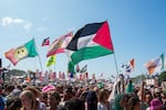 The flag of Palestine is waved in a crowd of festivalgoers at the hip hop trio Kneecap's performance during the Glastonbury Festival in Worthy Farm, Somerset, England, Saturday, June 28, 2025.