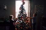 Children decorate a Christmas tree in this undated file photo.