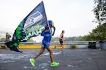 A man wearing a luchador mask and carrying a Seattle Seahawks flag competes in the Portland Marathon in Portland, Ore., Sunday, Oct. 6, 2019. The marathon's new route traveled through the Sellwood neighborhood.