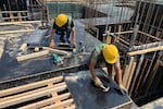 Construction workers build a housing compound in Beijing.