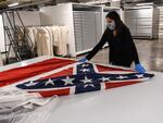 Director of Collections Nan Prince pulls out the Mississippi flag from the state's capitol on Sept. 25, 2020. The flag, the last state banner to feature a Confederate emblem, was permanently retired after Gov. Tate Reeves signed a bill ordering the flag's removal.