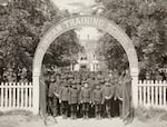 In this image, circa 1900s, students in uniforms pose in front of the Chemawa Indian Training School.