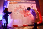 People color in a U.S. electoral map during a 2020 presidential election watch party at the U.S. Embassy in Ulaanbaatar, Mongolia.